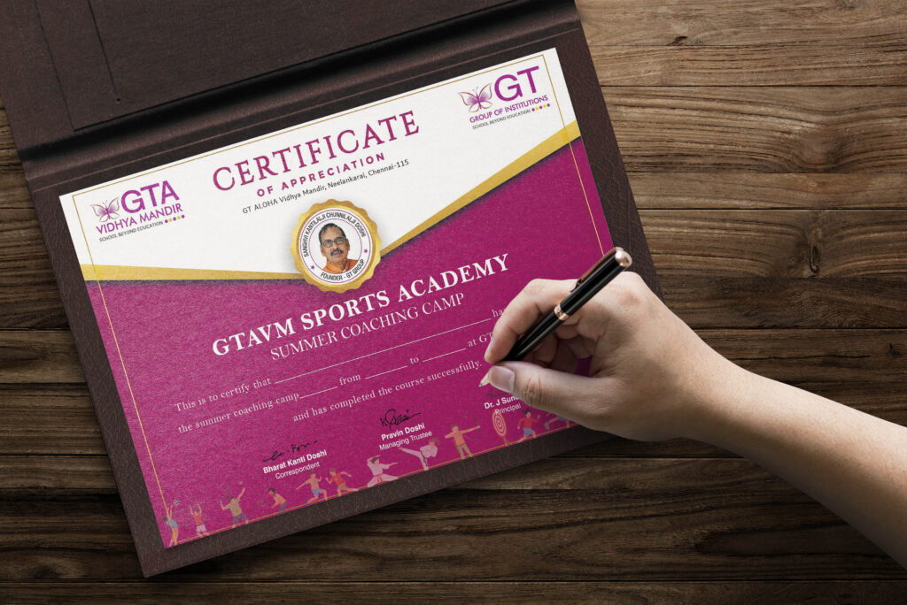 The image shows a certificate of appreciation for a sports academy's summer coaching camp, issued by GTA Vidya Mandir and GT Group of Institutions. The certificate is primarily magenta and white, featuring a portrait of the founder and signed by the correspondent, managing trustee, and principal. A hand is seen holding a pen, adding a personalized touch to the certificate. The background is a wooden surface, and the certificate design highlights quality printing and detailing, ideal for those looking for the best printing service in Chennai.
