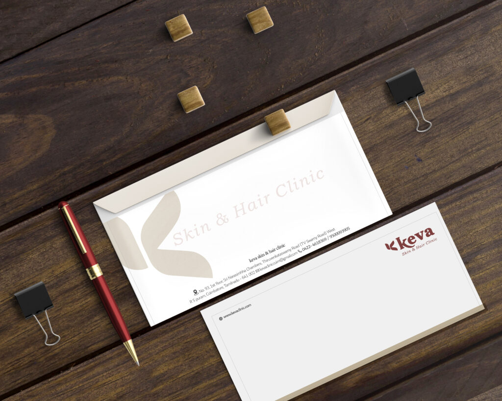 A white envelope and letterhead with "Skin & Hair Clinic" text, printed by a top printing service in Chennai, placed on a wooden surface alongside a red pen, binder clips, and metal clips.