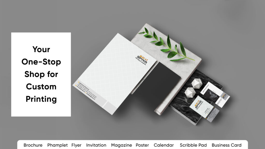 lA sleek and modern flat lay image showcasing various printed materials, including brochures, flyers, business cards, and pamphlets, with the text 'Your One-Stop Shop for Custom Printing' prominently displayed. Keywords such as brochure, pamphlet, flyer, invitation, magazine, poster, calendar, and business card are listed below. The design emphasizes professional printing services, suggesting the best printing service in Chennai.